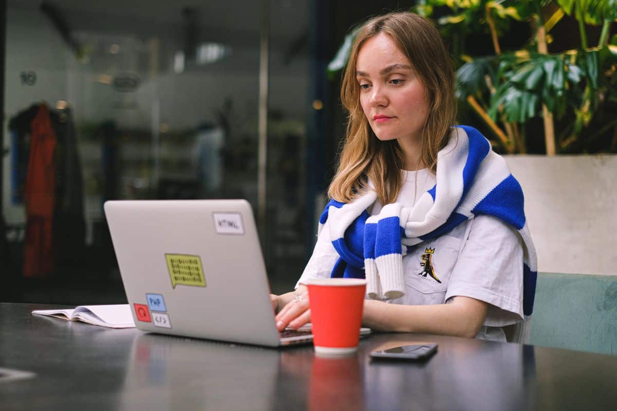 Une freelance marocaine travaille sur son ordinateur portable dans un café pour des clients internationaux