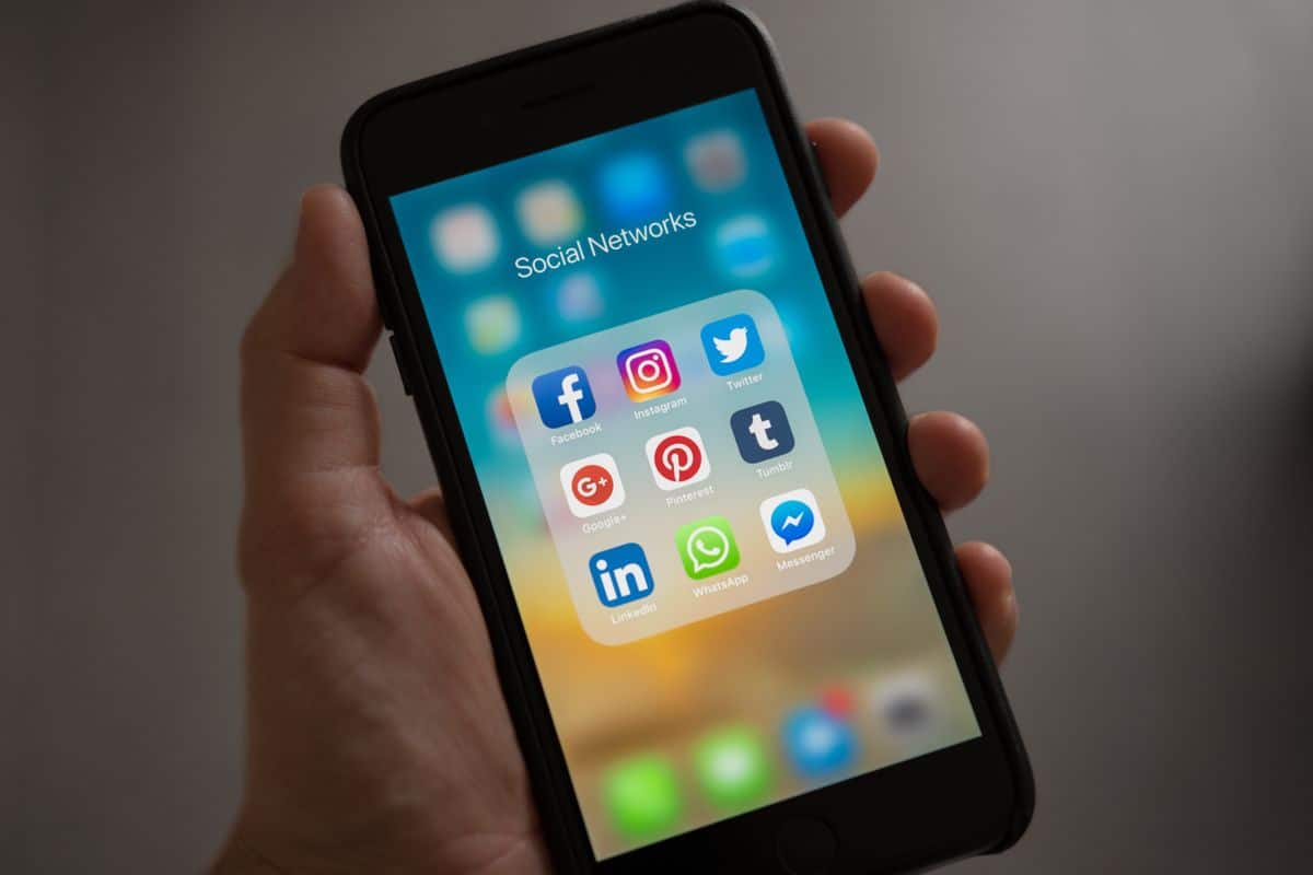 Une main tient un smartphone affichant les applications de réseaux sociaux les plus utilisées au Maroc